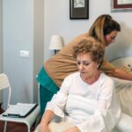Caregiver accommodating pillow to elderly patient