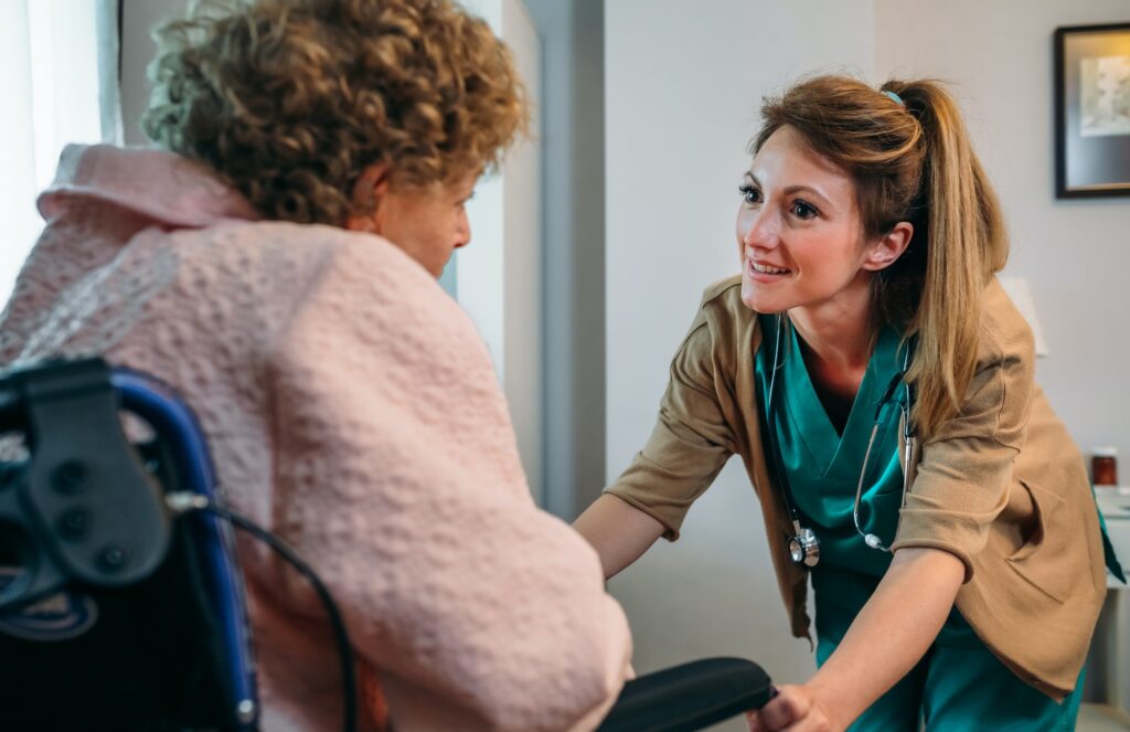Doctor talking to elderly patient in a wheelchair