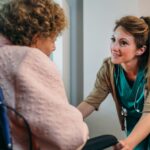 Doctor talking to elderly patient in a wheelchair