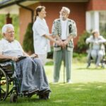 Group of senior patients with caregiver in the garden of nursing home