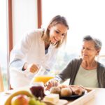 Health visitor and a senior woman during home visit.