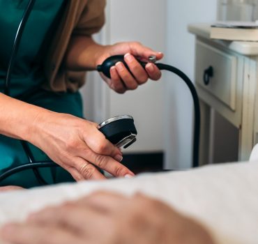 Caregiver checking blood pressure to a senior woman
