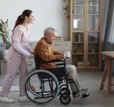 Female Caregiver Assisting Senior Man in Wheelchair